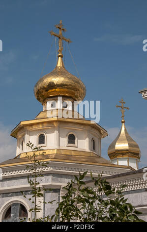 Several buildings in the grounds of the Russian Orthodox Church - the Dormition Cathedral - in Tashkent, Uzbekistan have shiny golden domes and roofs  Stock Photo