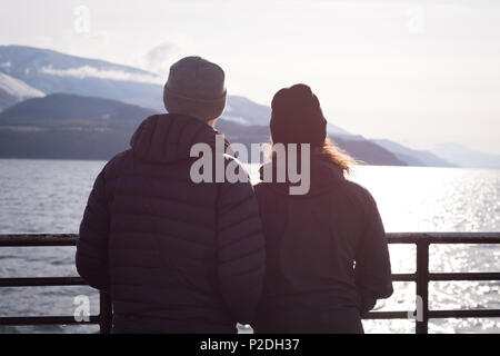Couple looking at river standing near river Stock Photo