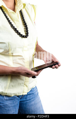 Close up of young woman wearing casual clothing, ring and necklace holding a smartphone on white background. Stock Photo