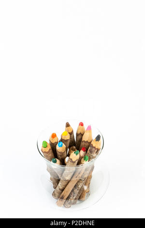 Close up of handmade wooden color pencils inside glass pot on white background. Stock Photo