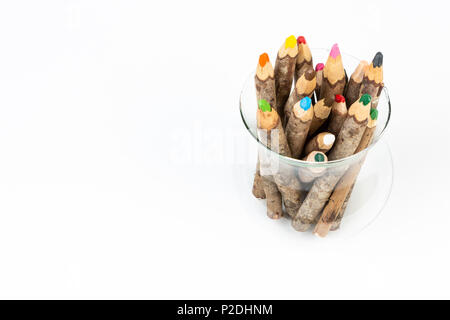 Close up of handmade wooden color pencils inside glass pot on white background. Stock Photo