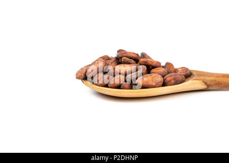 Close up of cocoa beans in wooden spoon on white background. Stock Photo