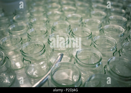 High angle close up of empty glass jars with wooden wicks, for candle making.  Stock Photo by Mint_Images