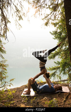 Sporty couple practicing acro yoga near the sea coast Stock Photo