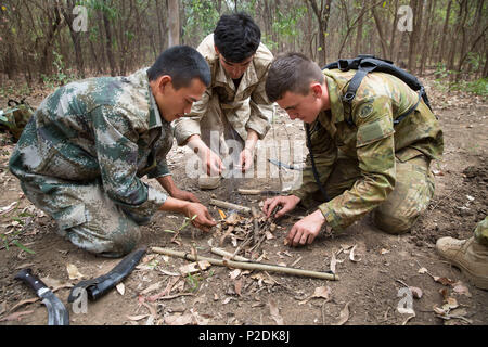 Australian Army, US Marine Corps and Chinese People's Liberation Army soldiers work together to get a fire going after walking off into the Daly River scrub in the Northern Territory to begin the five-day survival phase of Exercise Kowari on 4 September 2016. Kowari is an Australian army-hosted survival skills exercise designed to increase defense cooperation between forces from the U.S., Australia and China. (Australian Defence Force photo by Cpl. Jake Sims) Stock Photo