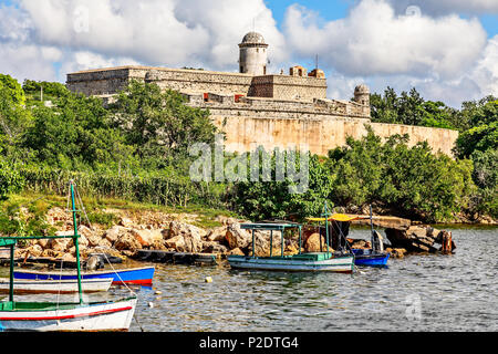 Jagua castle fortified walls with trees and fishing boats in the foreground, Cienfuegos province, Cuba Stock Photo