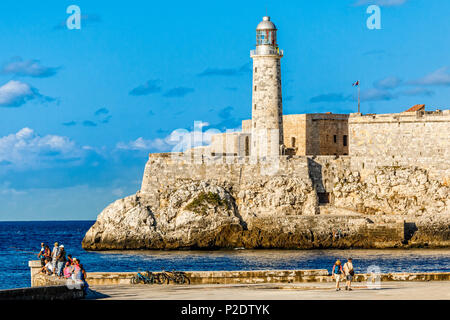 El Morro spanish fortress walls with lighthouse, walking people and fishermen in the foreground, Havana, Cuba Stock Photo