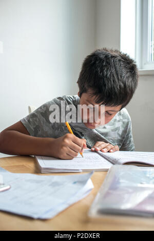 Surrey,UK-primary school pupil working on maths homework Stock Photo