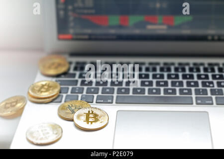 Close up of golden bitcoins on computer keyboard and screen Stock Photo