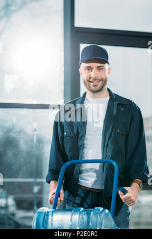 Loader holding delivery cart with water bottles Stock Photo