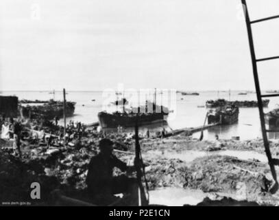 . Australian War Memorial (AWM) catalog number 042890 Tarakan, Borneo. 1945-05. Landing Ship, Tanks which landed troops of the 9th Division AIF and units of the RAAF at Tarakan. Destroyed oil tanks, bombed and bombarded, are in the foreground. May 1945. Australian military 44 Red Beach Tarakan (042890) Stock Photo