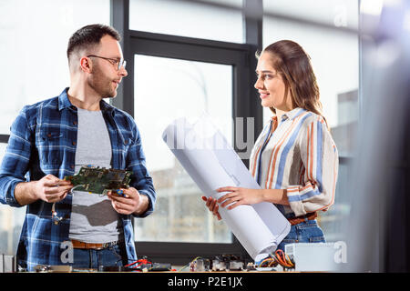 Engineers working on project holding circuit board and blueprint Stock Photo