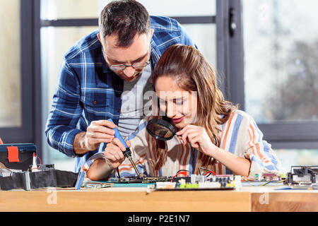 Female and male engineers soldering circuit board Stock Photo