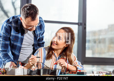 Team of engineers checking circuit board with multimeter Stock Photo