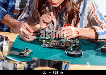 Team of engineers working with circuit board and multimeter Stock Photo