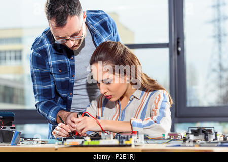 Woman and man engineers testing circuit board Stock Photo