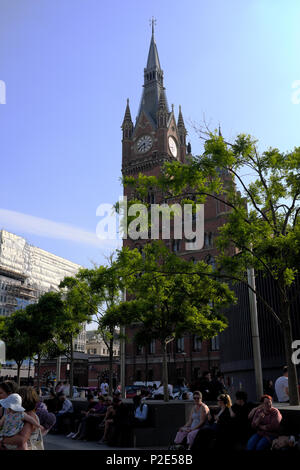 People sitting in Kings Cross courtyard with St. Pancras railway station in backgroundLondon, England, UK Stock Photo