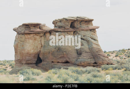 An isolated, interesting rock formation in a desert field. Stock Photo