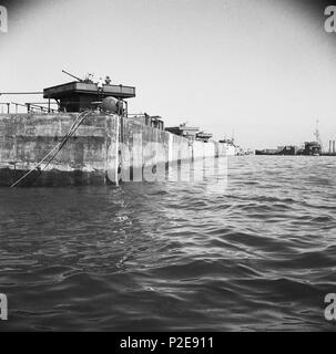 A line of Phoenix caissons in place at Arromanches, with anti-aircraft guns installed. June 12, 1944 Stock Photo