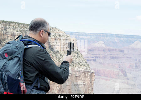 A man filming the Grand Canyon with a GoPro camera. Stock Photo