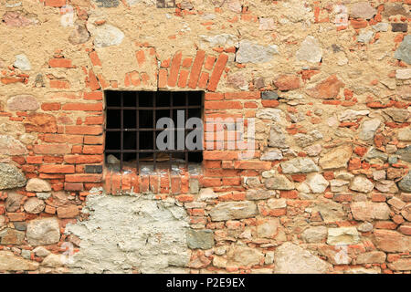 Rusty window grille and old block brick wall Stock Photo