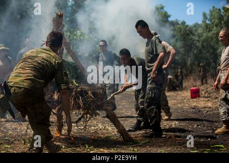 An Australian Army soldier and People’s Liberation Army soldiers build a signal fire during Exercise Kowari at Daly River Region, Northern Territory, Australia, Sept. 3, 2016. The purpose of Exercise Kowari is to enhance the United States, Australia, and China’s friendship and trust, through trilateral cooperation in the Indo-Asia-Pacific region. (U.S. Marine Corps photo by Lance Cpl. Osvaldo L. Ortega III/Released) Stock Photo