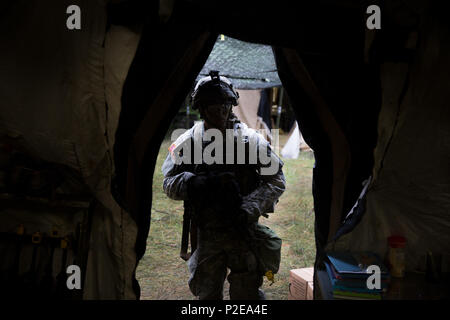 A U.S. Army Soldier of Brigade Engineer Battalion enters command tent while joining command briefing during exercise Combined Resolve VII at the U.S. Army’s Joint Multinational Readiness Center in Hohenfels Germany, Sept. 5, 2016. Combined Resolve VII is a 7th Army Training Command, U.S. Army Europe-directed exercise, taking place at the Grafenwoehr and Hohenfels Training Areas, Aug. 8 to Sept. 15, 2016. The exercise is designed to train the Army’s regionally allocated forces to the U.S. European Command. Combined Resolve VII includes more than 3,500 participants from 16 NATO and European part Stock Photo