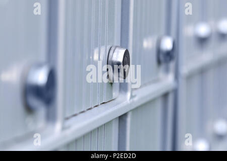 Real apartment mailboxes in metal at entrance of modern residential building. Close up of lock from mail boxes of metallic postal block. Modern and fa Stock Photo