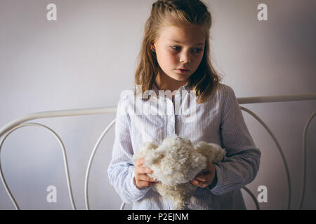 Sad girl holding a teddy bear Stock Photo