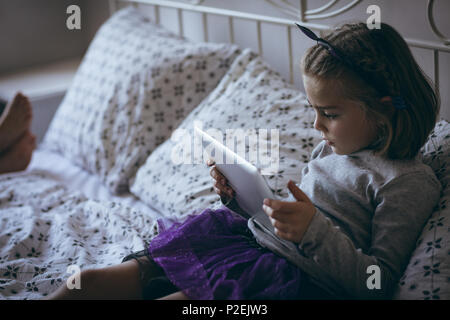Girl using digital tablet on bed Stock Photo