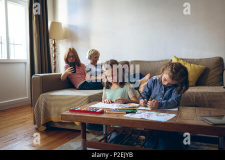 Sisters doing their homework in living room Stock Photo