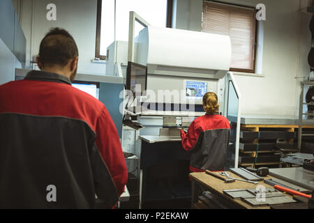 Two workers checking machine Stock Photo