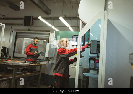 Two workers checking machine Stock Photo