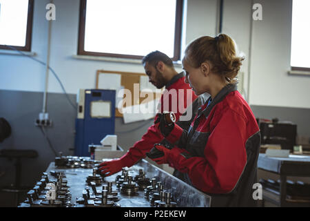 Two workers checking machine parts Stock Photo