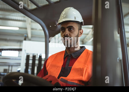 Male worker driving forklift Stock Photo