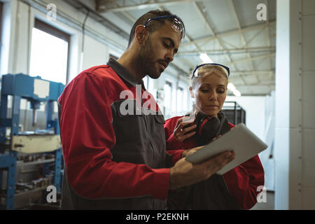 Two workers discussing over digital tablet Stock Photo