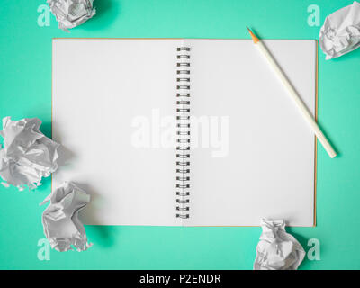 Flat Lay of Blank  Notebook, White Pencil and Crumpled Ball Paper on Aqua Green Blue Background. Top View Get Idea Concept Stock Photo