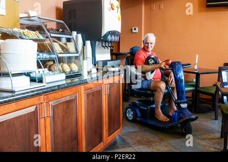 Florida Clearwater,Holiday Inn Express,hotel,motel,free breakfast buffet,dining room,senior seniors citizen citizens,man men male,electric cart wheelc Stock Photo