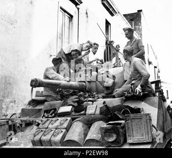 Invasion of Italy - British fifth army advances north of Naples. Picture shows: Citizens of the town od Casoria come out on their balconies to watch a British tank man having a quick shave on top of his tank in the street. Stock Photo