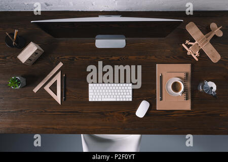 top view of desktop computer and office supplies on wooden table Stock Photo