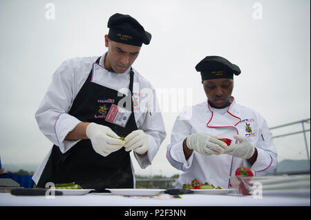 160901-N-LD343-001 SAN PEDRO, California (Sept. 1, 2016) – Culinary Specialist 2nd Class Anabel Aquino, left, and Culinary Specialist 3rd Class Brittney Wilson, both assigned to amphibious assault ship USS America (LHA 6), prepare fruits and vegetables for the TV pre-recording of the first cooking competition 'Galley Wars' held on the Battleship Iowa Memorial, during the inaugural Los Angeles Fleet Week. This year, America takes on mine countermeasure ship USS Champion (MCM 4), Coast Guard Base Los Angeles/Long Beach, and Arleigh Burke-class guided missile destroyer USS Wayne E. Meyer (DDG 108 Stock Photo