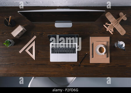 top view of desktop computer, laptop and office supplies on wooden table Stock Photo