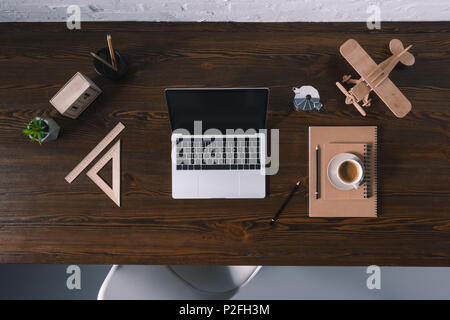 top view of laptop with blank screen and office supplies on wooden table Stock Photo