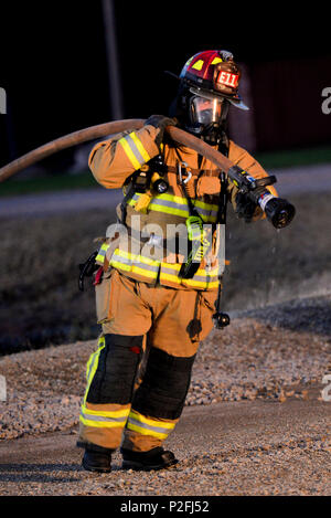Kirk Buggert, 788th Civil Engineer Squadron lead firefighter, pulls a hose away from an aircraft’s fuselage after successfully putting out a fire during a training exercise at their burn pit, Sept. 19, 2016 at Wright-Patterson Air Force Base, Ohio. Aircraft fire training is conducted routinely throughout the year to ensure crews are ready should the need ever arise. (U.S. Air Force photo by Wesley Farnsworth) Stock Photo
