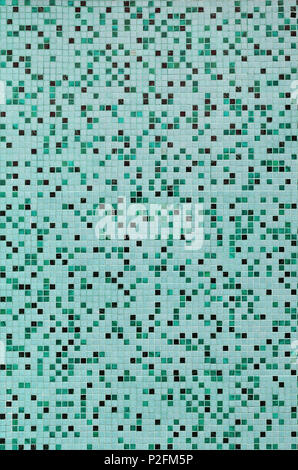 The texture of the wall, decorated with a mosaic of various small square tiles. Abstract pattern of ceramic tiles on the wall Stock Photo
