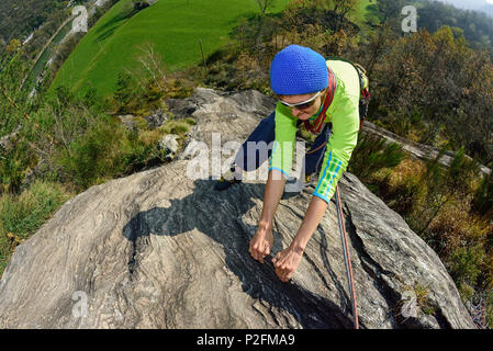 Woman climbing on Gneiss rock, Torbeccio, valley of Maggia, Ticino, Switzerland Stock Photo
