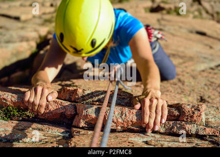 Woman climbing on red Granite rock, Mottarone, Piedmont, Italy Stock Photo