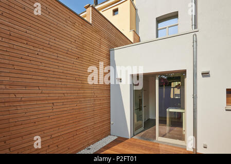 Wall construction with insulating wood cladding in countryard Stock Photo