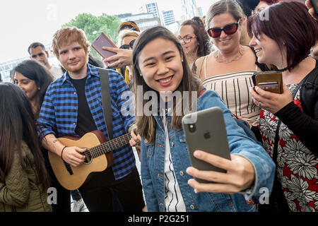 London, UK. 14th June 2018. Madame Tussauds unveil Ed Sheeran waxwork model at Wembley Park station for photo-selfies with locals including police officers. Credit: Guy Corbishley/Alamy Live News Stock Photo