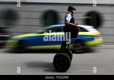 15 June 2018, Germany, Freiburg: Police officer Janka Schmidt passing by a police vehicle while riding on a Segway in downtown Freiburg. The Police in Freiburg will be shortly deploying Segways on a permanent basis. A pilot test started 10 months ago was succesful. Photo: Patrick Seeger/dpa Credit: dpa picture alliance/Alamy Live News Stock Photo